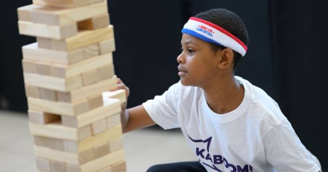 A kid plays with blocks during an activity.